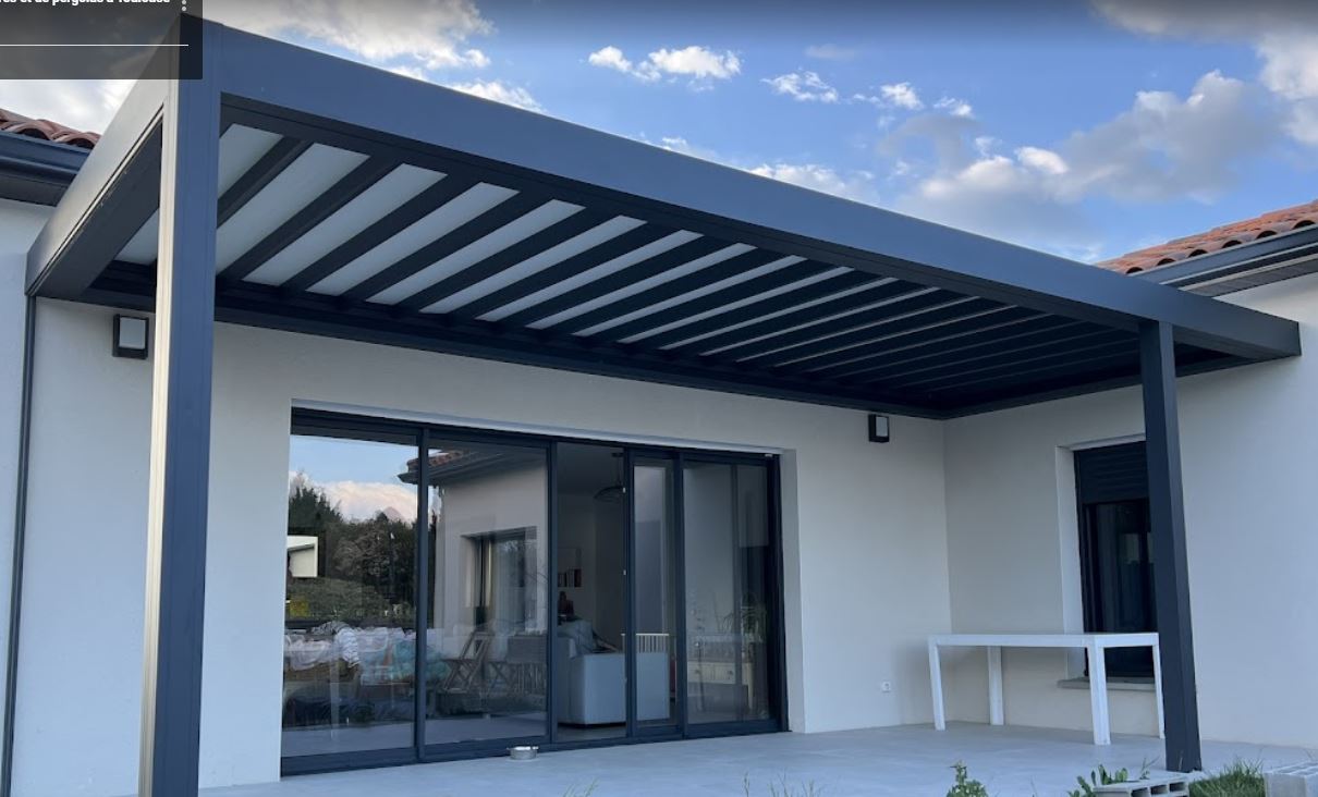 Pergola bioclimatique grise sur facade maison moderne avec baies vitrees et table. "stores et de pergolas a Toulouse".