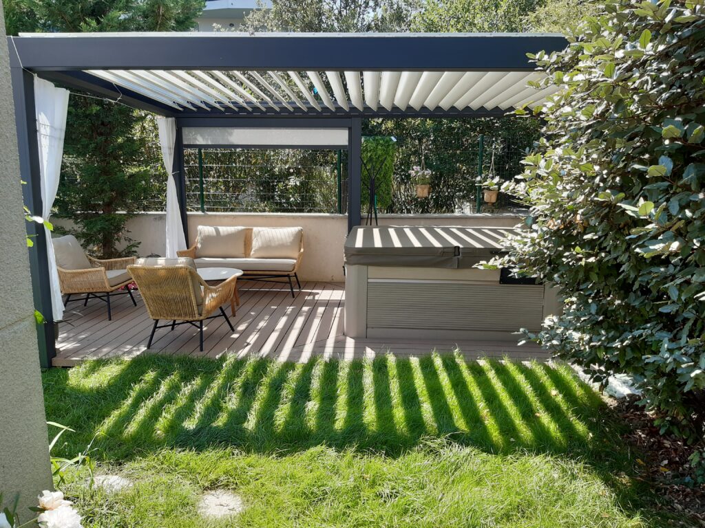 Pergola bioclimatique et spa : aménagement de terrasse moderne Terrasse moderne avec pergola bioclimatique noire, équipée d'un spa et d'un salon de jardin en rotin. Lumière du soleil créant des ombres rayées.