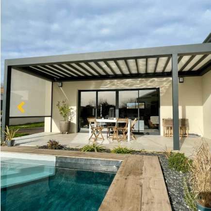 Pergola bioclimatique anthracite sur terrasse moderne avec store vertical beige. Vue sur la piscine et les baies vitrées de la maison.