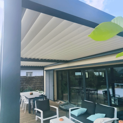 Terrasse moderne avec pergola rétractable à toile plissée, salon de jardin confortable et salle à manger extérieure sur deck en bois.