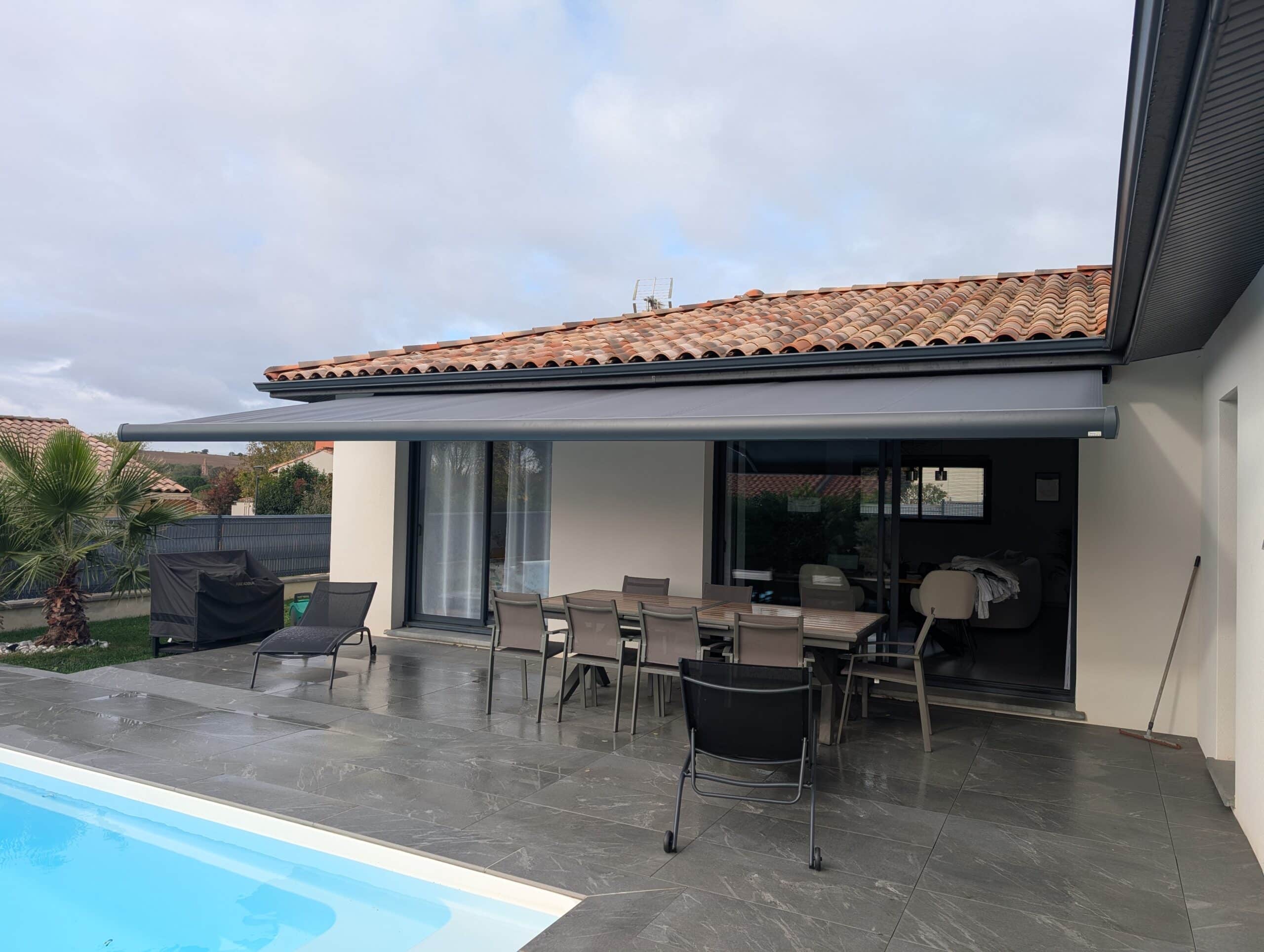 Terrasse moderne avec store banne gris déployé.