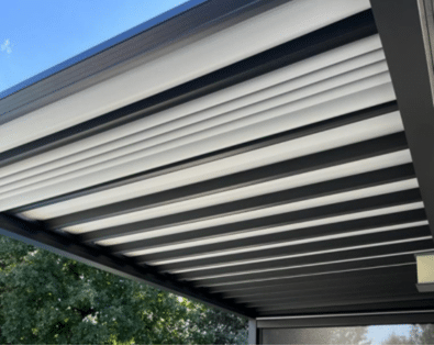 Pergola bioclimatique noire à toile rétractable blanche semi-ouverte. Ombrage moderne pour terrasse.