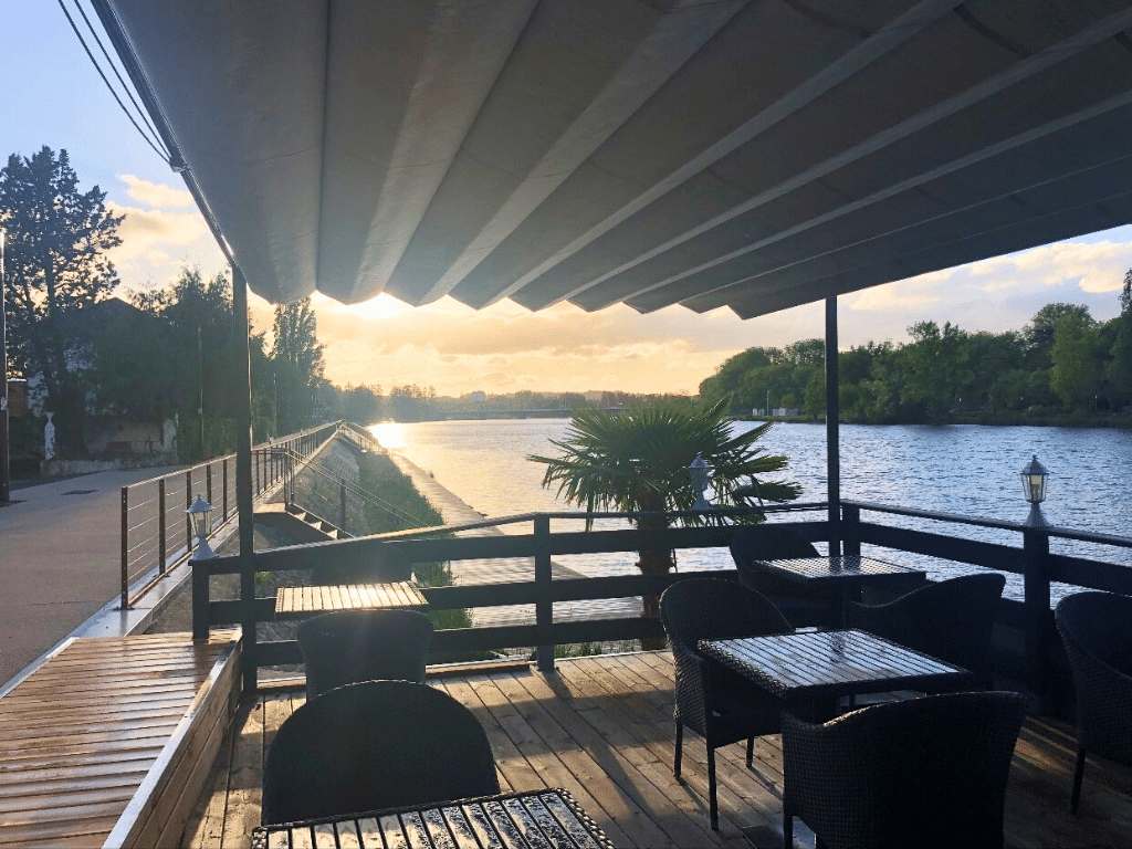 Pergola Vélum sur une terrasse de restaurant au bord de l'eau.