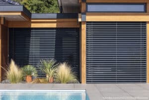 Façade bois avec brise-soleil Lamisol, piscine et plantes. Vision Bois Construction / Eco Design Menuiserie.