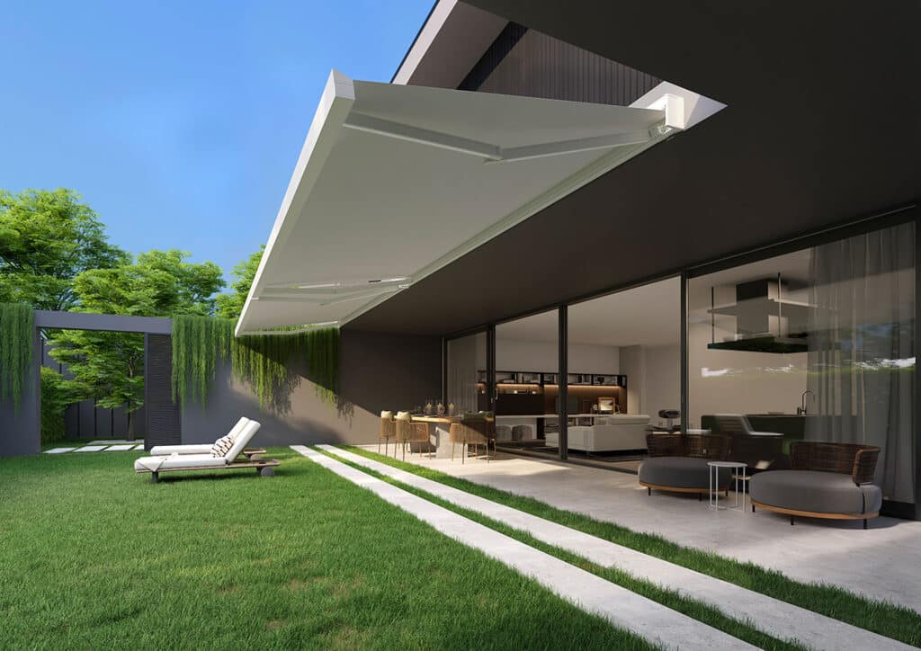 Store banne blanc rétractable sur une terrasse moderne avec mobilier de jardin et pelouse.